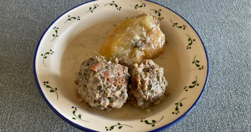 Töltött paprika két húsgombóccal díszes tányéron